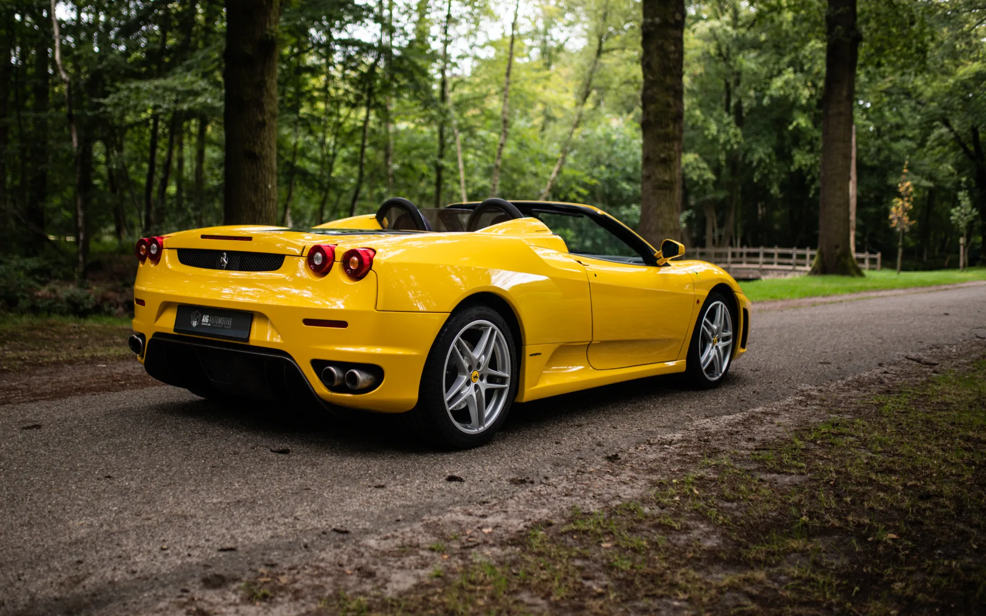 Achterkant van een gele Ferrari F430 Spider bij AIG Automotive